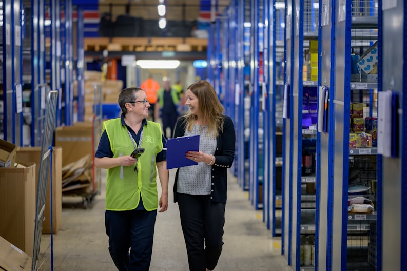 two people walking in a warehouse with clipboard