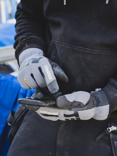 gloved hands holding a mobile phone